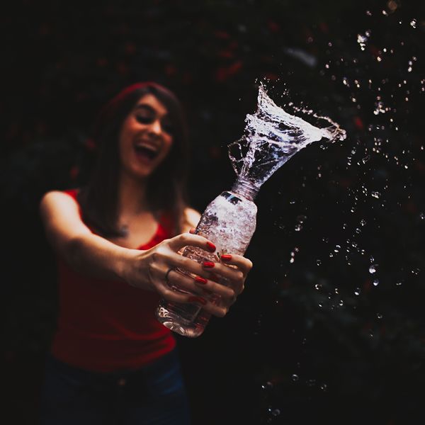 woman holding a plastic water bottle